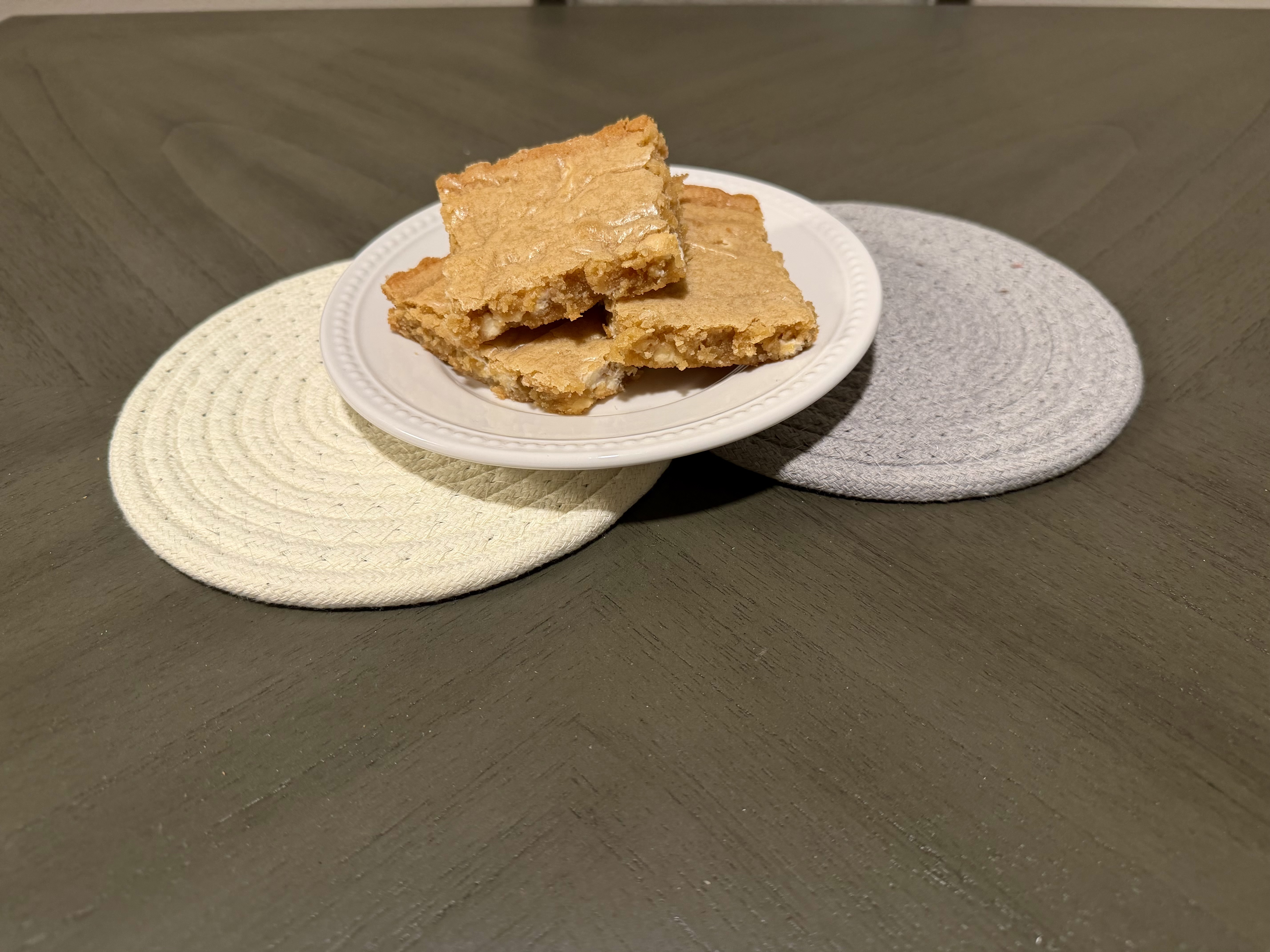 Plate of golden white chocolate chip blondies.